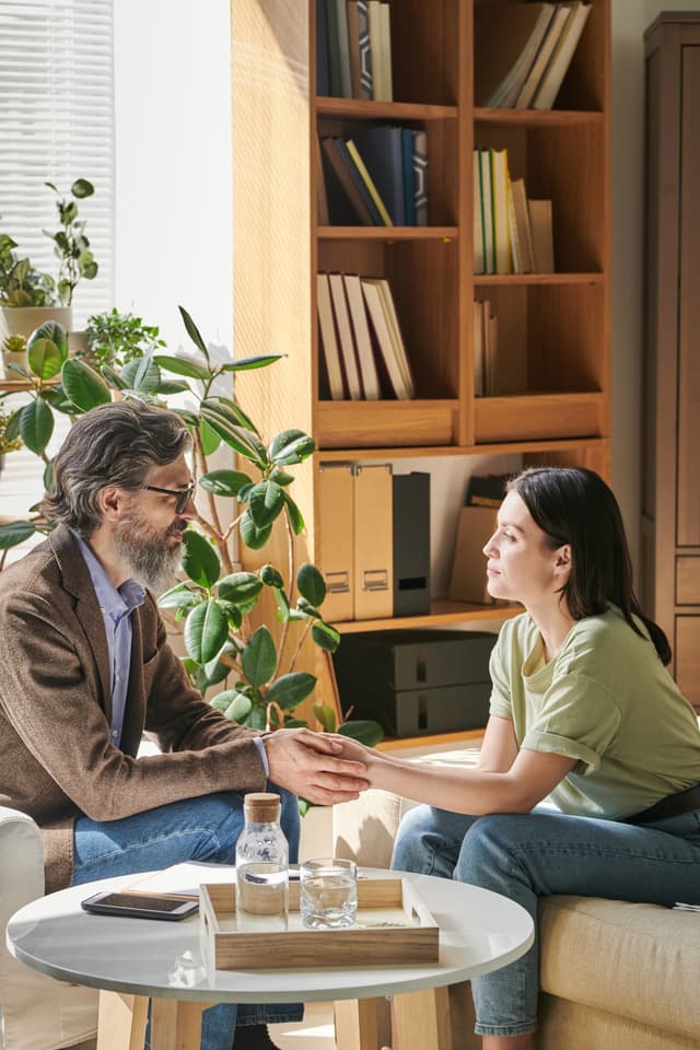 Therapist and client sitting on bed